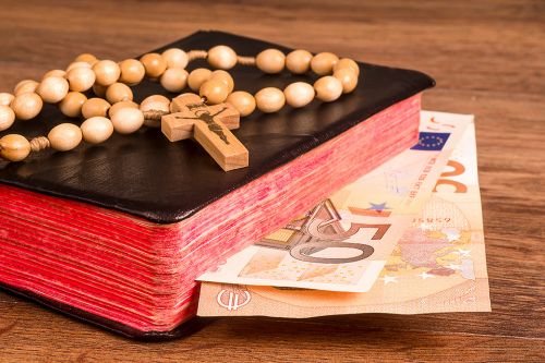 © GieZetStudio - stock.adobe.com Foto: Bibel und Geldscheine